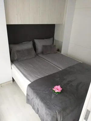 a bed with a pink flower in a bowl on it at Apartments Drevi in Ljubljana