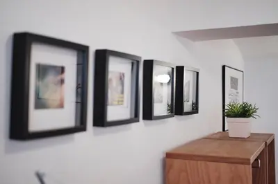 a row of framed pictures on a white wall at Apartment Center in Kamnik