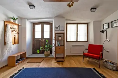 a living room with a red chair and a door at Apartment Center in Kamnik