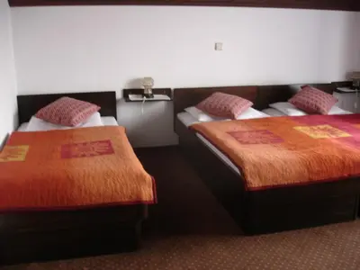 a hotel room with two beds with orange blankets at Tiffany Pension Bled in Bled