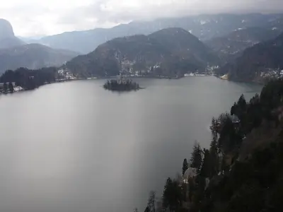an island in a large body of water with mountains at Tiffany Pension Bled in Bled