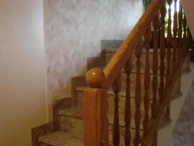 a stairway with a wooden rail and stairs with a stair case at Tiffany Pension Bled in Bled