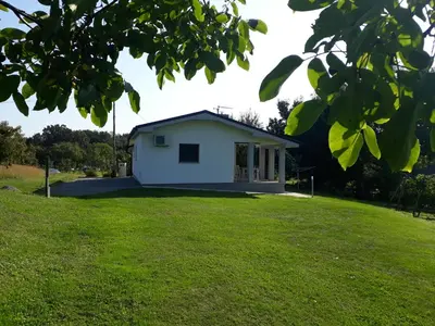 a small white house on a grassy field at NA OFF in Radenci