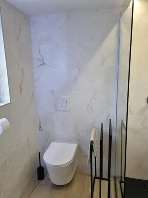 a white bathroom with a toilet and a shower at NA OFF in Radenci