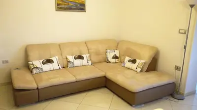 a brown couch in a living room with pillows on it at VILLA ČEH in Gabrovica pri Črnem Kalu