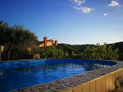 a swimming pool in front of a house at VILLA ČEH in Gabrovica pri Črnem Kalu