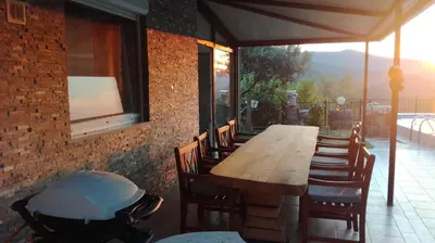 a large wooden table and chairs on a patio at VILLA ČEH in Gabrovica pri Črnem Kalu