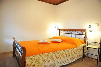 a bedroom with an orange bed with two pillows on it at Apartmaji Kumar in Šmartno