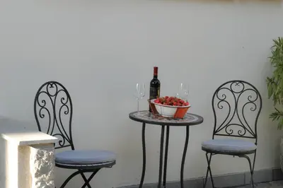 a table with a bottle of wine and two chairs at Apartmaji Kumar in Šmartno