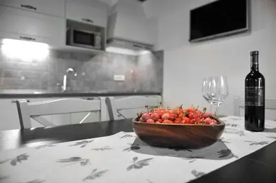 a bowl of fruit sitting on a table with a bottle of wine at Apartmaji Kumar in Šmartno