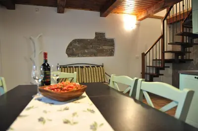 a table with a bowl of fruit and a bottle of wine at Apartmaji Kumar in Šmartno