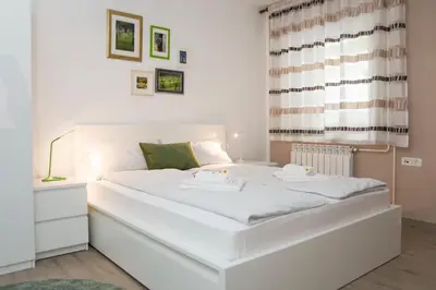 a large white bed in a room with a window at Apartment Vidus Wine Estate in Podnanos