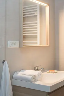 a bathroom with a sink and a mirror and towels at Apartment Vidus Wine Estate in Podnanos