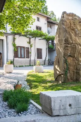 a stone bench in front of a building at Apartment Vidus Wine Estate in Podnanos