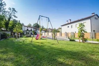 an empty playground with swings in a yard at Apartment Vidus Wine Estate in Podnanos