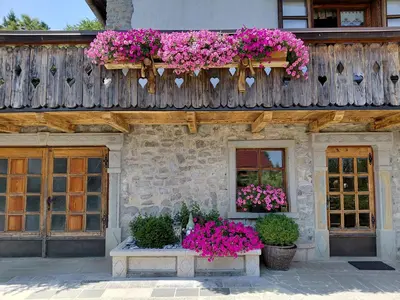 a building with a bunch of pink flowers on it at Apartma Alpski vrt in Vojsko