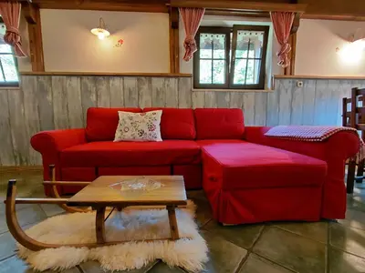 a living room with a red couch and a table at Apartma Alpski vrt in Vojsko