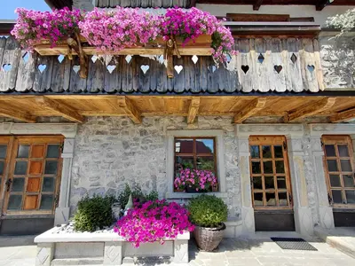 a building with lots of flowers on a balcony at Apartma Alpski vrt in Vojsko