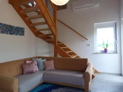 a living room with a couch and a staircase at HišaŠmihelka in Kobarid