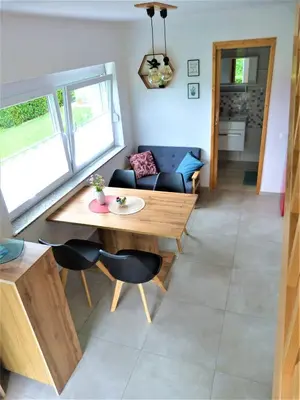 a living room with a wooden table and chairs at HišaŠmihelka in Kobarid