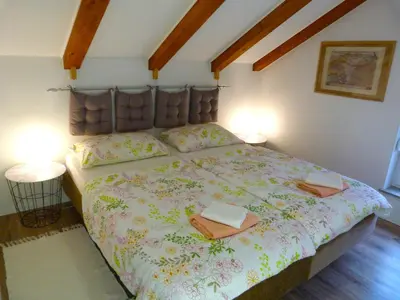a bedroom with a large bed with two books on it at HišaŠmihelka in Kobarid