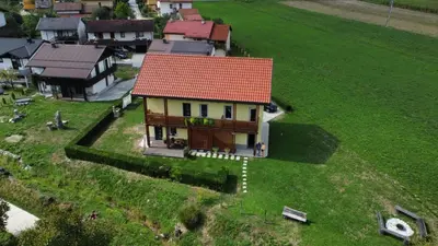 a small house with a red roof on a green field at HišaŠmihelka in Kobarid