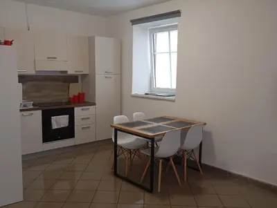 a kitchen with a table and some white cabinets at Soca treasure with free parking in Bovec