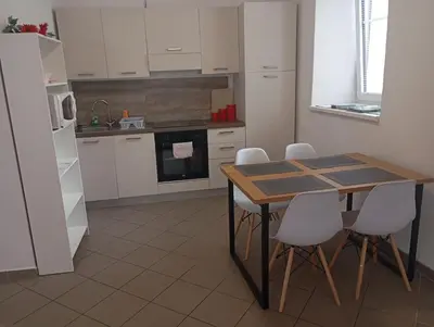 a kitchen with a wooden table and white cabinets at Soca treasure with free parking in Bovec