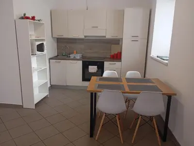 a kitchen with a wooden table and white cabinets at Soca treasure with free parking in Bovec