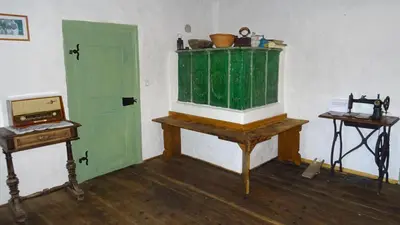 a room with a green door and a desk and a table at Homestay Kapl in Ledinek