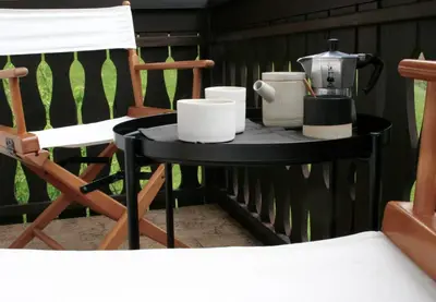 a black table with cups and a tea kettle and a chair at Village House in Železniki