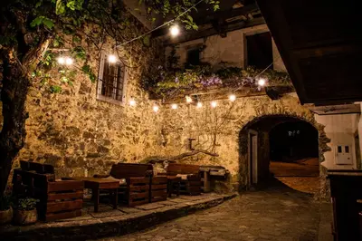 a room with a stone wall with lights on it at Boutique Rooms & Winery Žorž in Vipava