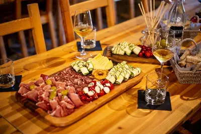 a table with two plates of food and glasses of wine at Boutique Rooms & Winery Žorž in Vipava