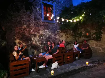 a group of people sitting at tables at night at Boutique Rooms & Winery Žorž in Vipava