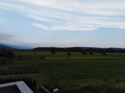 a view of a green field with a fence at Jasna rooms in Ilirska Bistrica