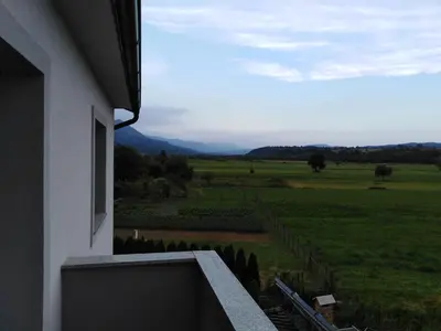 a view of a green field from a building at Jasna rooms in Ilirska Bistrica
