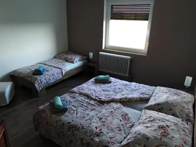 a bedroom with two beds and a window at Jasna rooms in Ilirska Bistrica