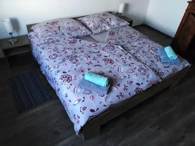 a bedroom with a bed with a pink comforter at Jasna rooms in Ilirska Bistrica