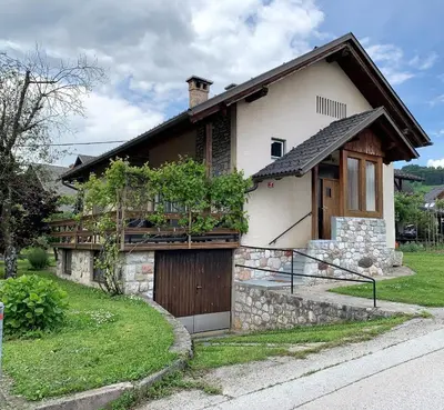 a house with a wooden door and a balcony at House Amalia in Bled
