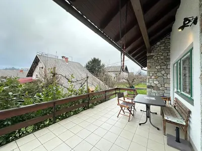 a patio with a table and chairs on a balcony at House Amalia in Bled