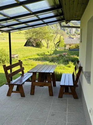 two benches and a picnic table on a patio at Jack's Apartments in Bled