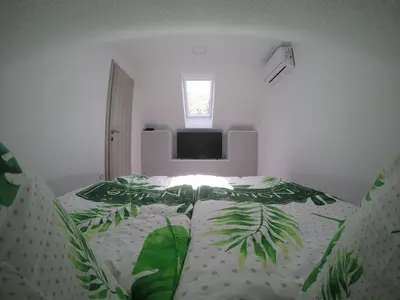 a bedroom with a bed with a green leaf design at Jack's Apartments in Bled