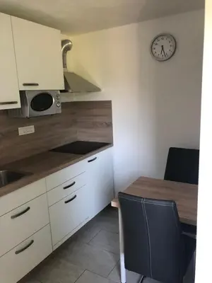 a kitchen with a table and a clock on the wall at Jack's Apartments in Bled