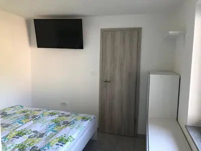 a bedroom with a bed and a television on the wall at Jack's Apartments in Bled