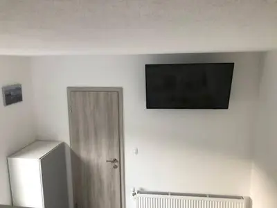 a flat screen tv on a wall next to a refrigerator at Jack's Apartments in Bled