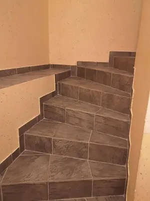 a set of stairs in a room with brown tile at Sobe SM0LEJ in Bled