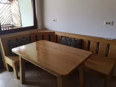 a wooden table and chairs in a room with a window at Sobe SM0LEJ in Bled
