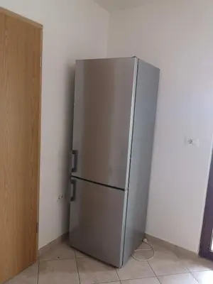 a stainless steel refrigerator in a corner of a room at Sobe SM0LEJ in Bled