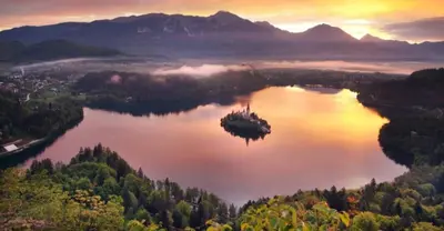 an island in the middle of a lake at sunset at STUDIO LUNA in Bled