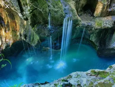 a pool of water in a cave with waterfalls at STUDIO LUNA in Bled